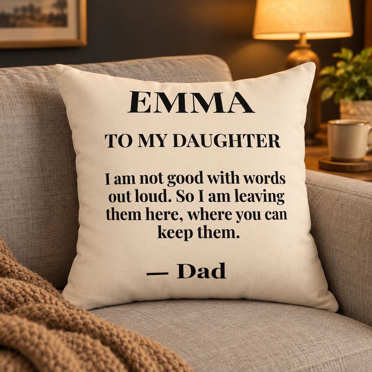 To My Daughter personalized pillow from Dad on a sofa, cream with black serif letter
